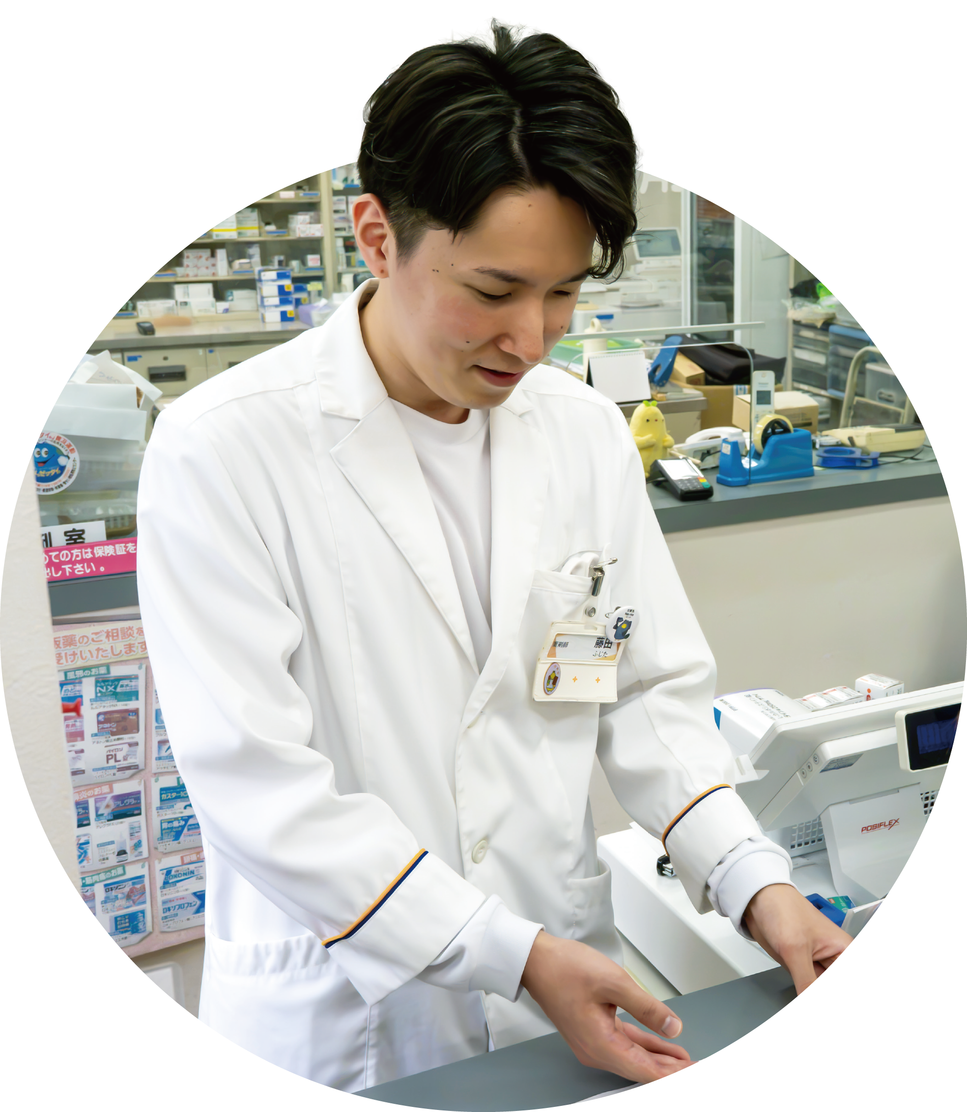 白衣姿で調剤する藤田奨さん